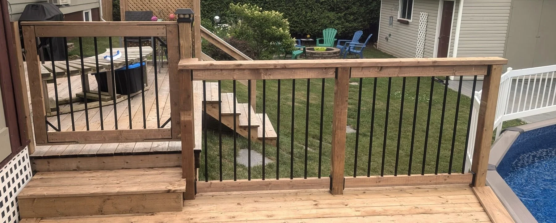 Custom designed and built pressure treated wood and black aluminum railings and gate on pool deck built for home owner in Kensington, PEI.