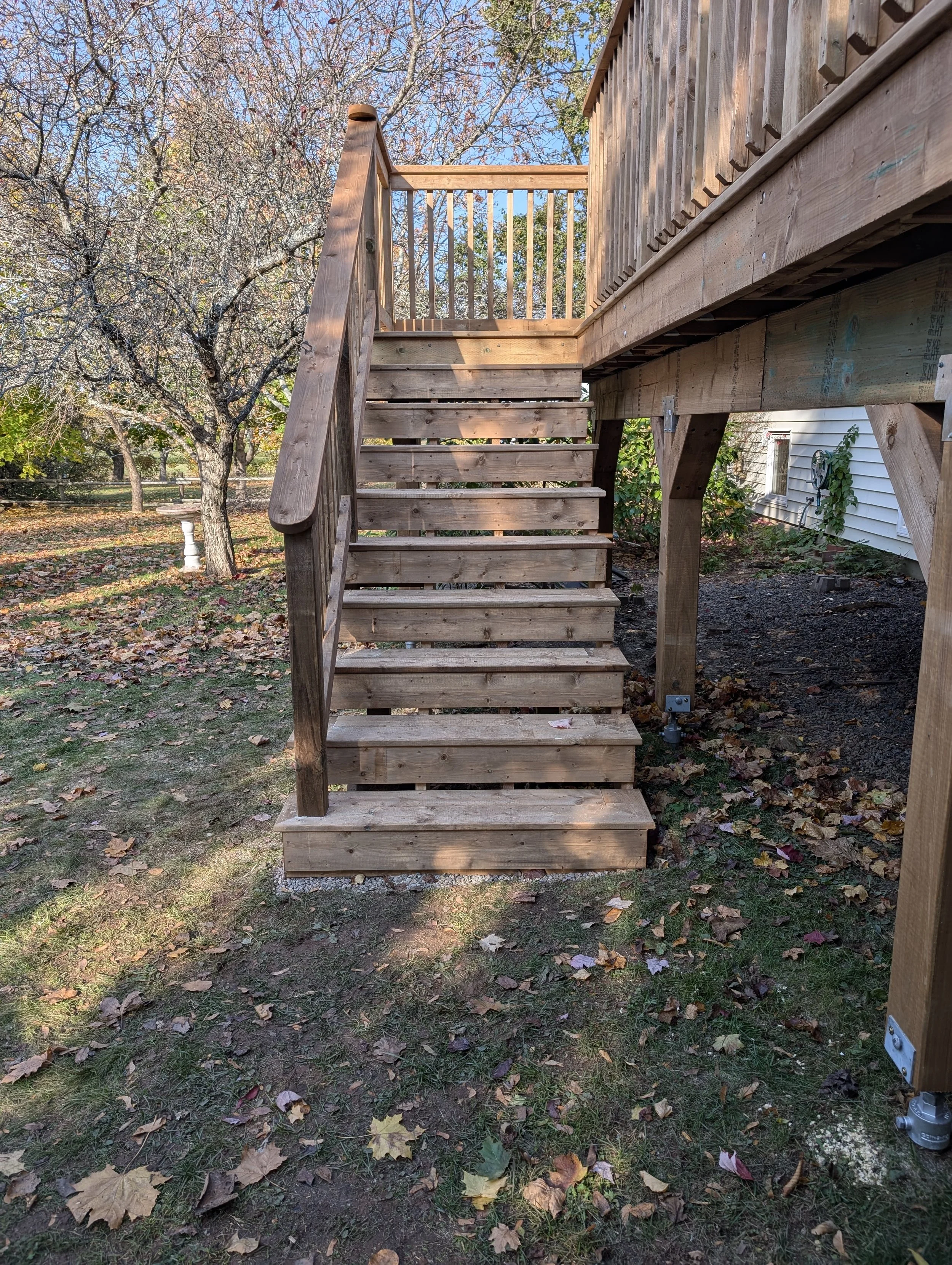 Custom design and built, pressure treated, raised wooden deck with stairs and wood railing built for homeowner in Stratford, PEI