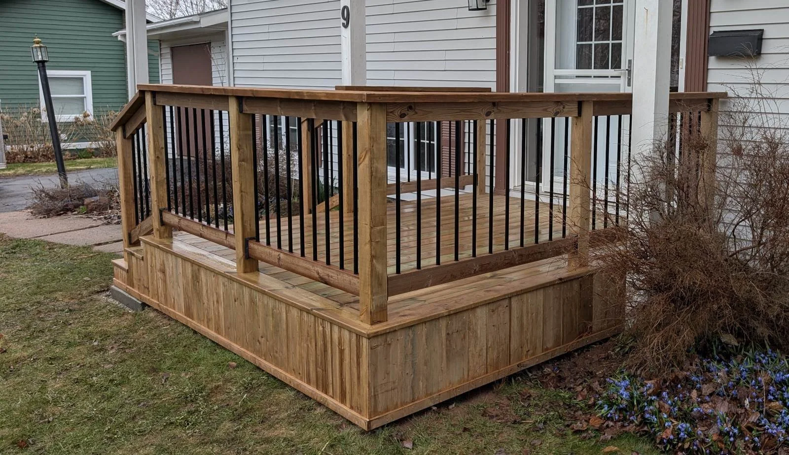 Custom designed and built pressure treated wood and black aluminum railings on front step built for home owner in Charlottetown, PEI.