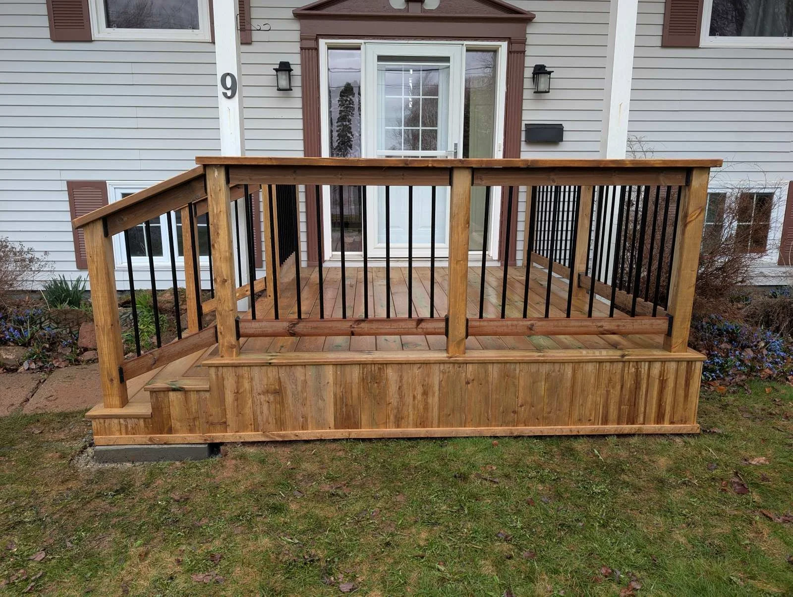 Custom designed and built pressure treated wood and black aluminum railings on front step built for home owner in Charlottetown, PEI