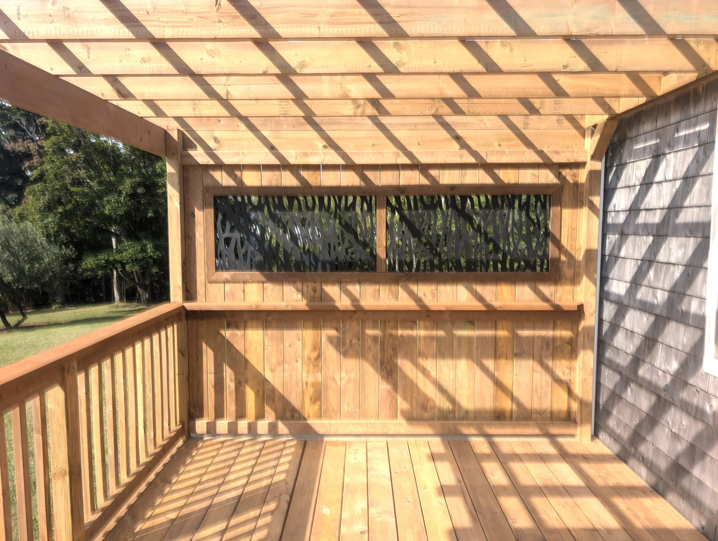 Custom pressure treated wood pergola with privacy insert built for a homeowner in Trout River, PEI  