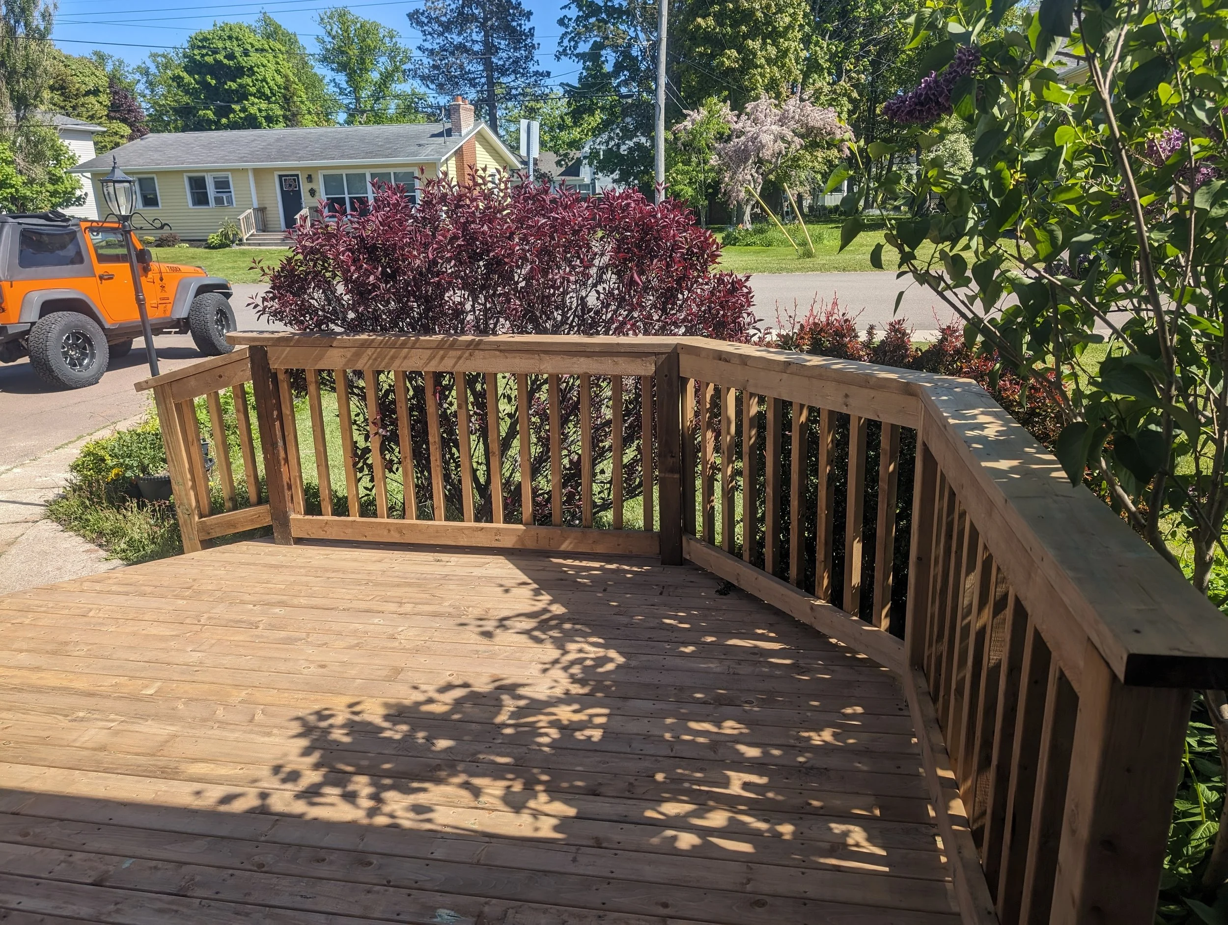 Custom built, pressure treated wood entry-way deck with wood railings built for a home owner in Charlottetown, PEI