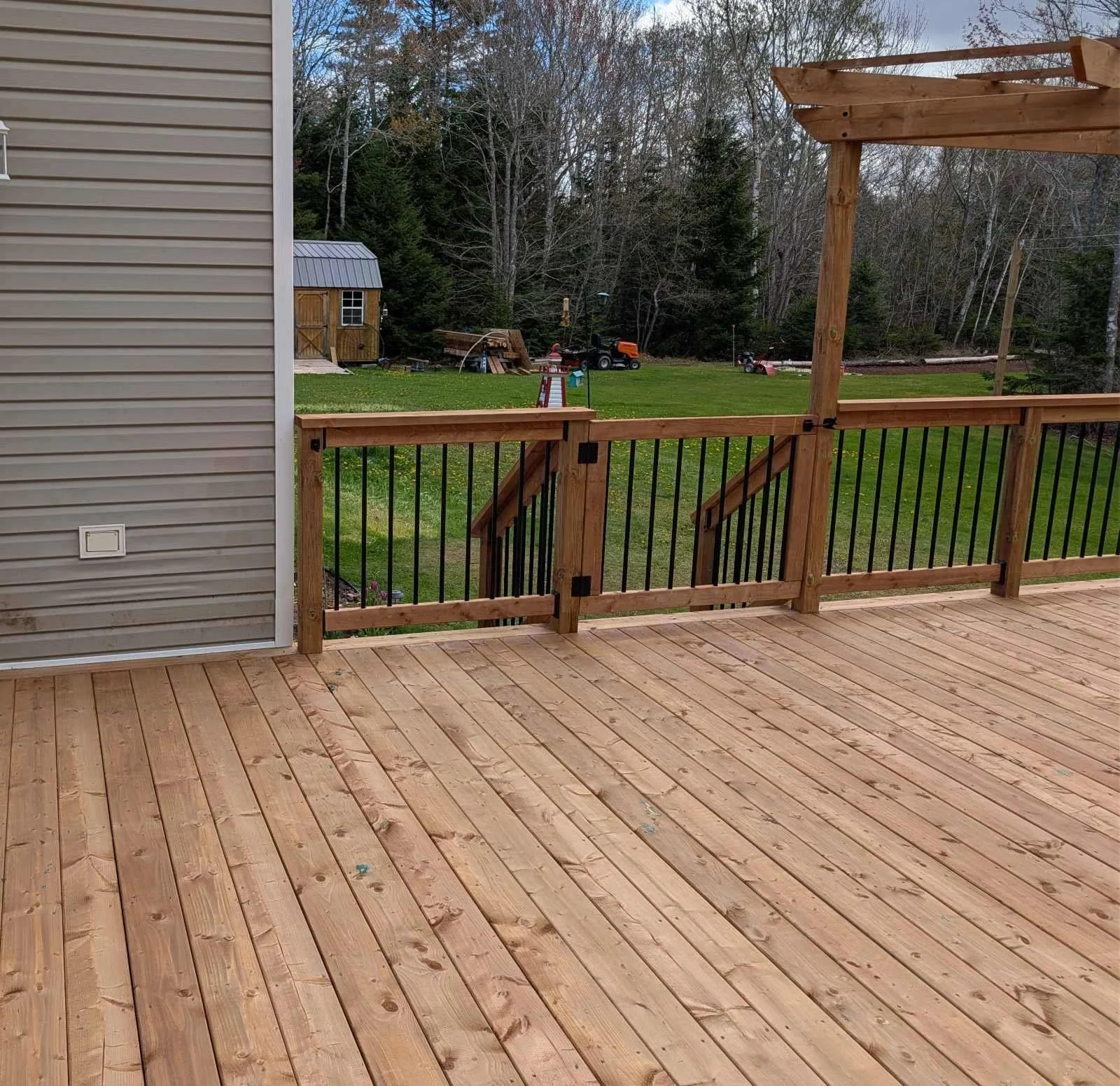 Custom designed and built pressure treated wood and black aluminum railings with gate on deck built for home owner in Brackley Beach, PEI.