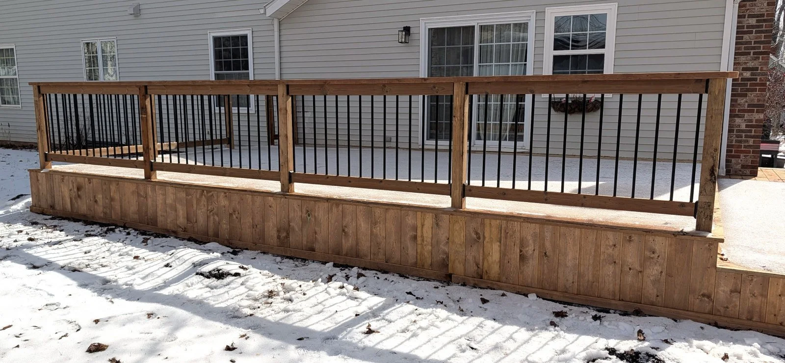 Custom designed and built pressure treated wood and black aluminum railings on deck built for home owner in Charlottetown, PEI