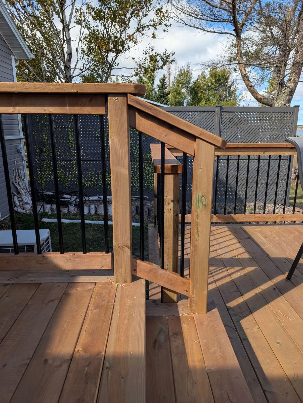 Custom designed and built pressure treated wood and black aluminum railings on multi level deck built for home owner in West Covehead, PEI.