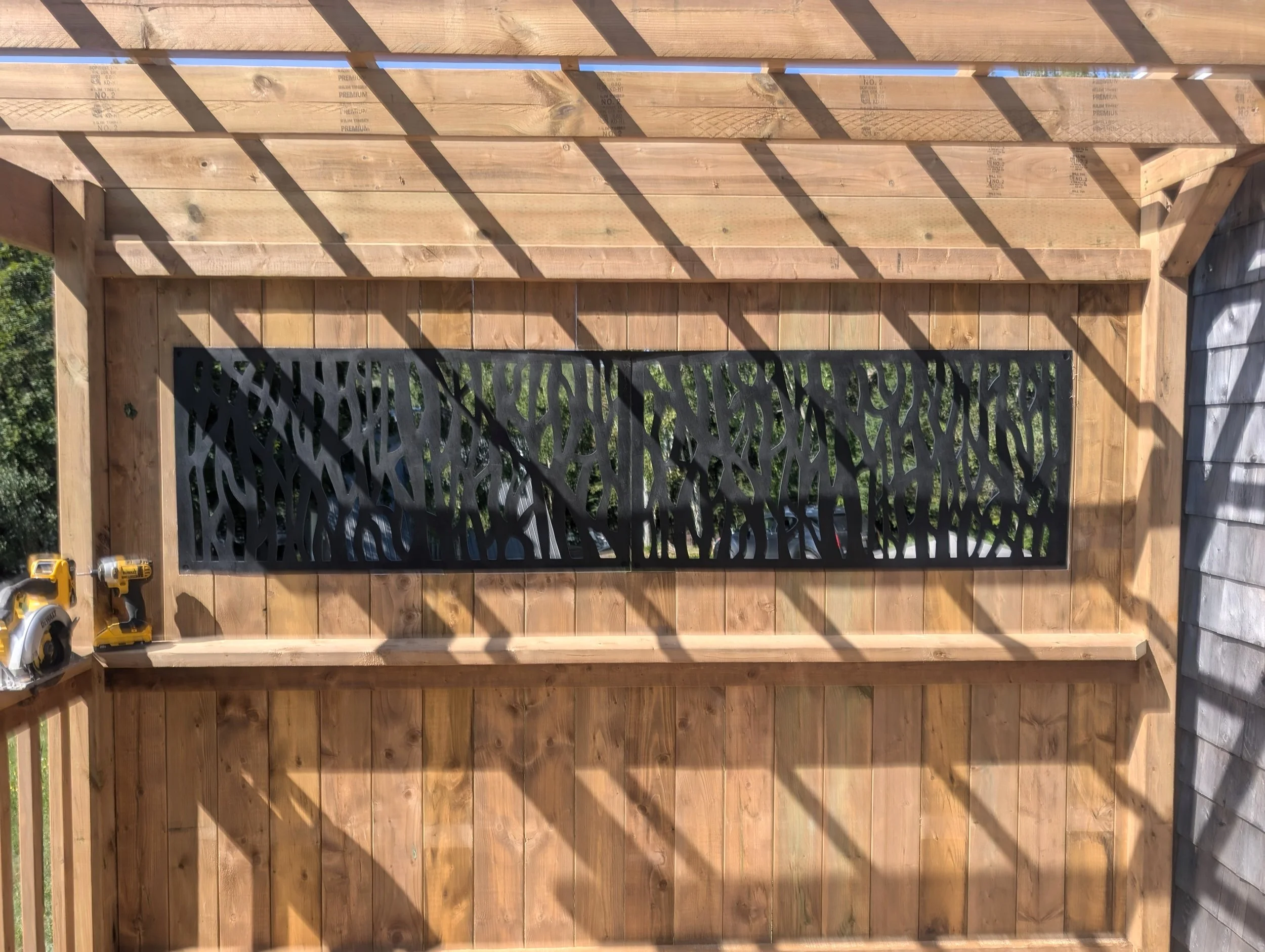 Custom pressure treated wood pergola with privacy insert built for a homeowner in Trout River, PEI  
