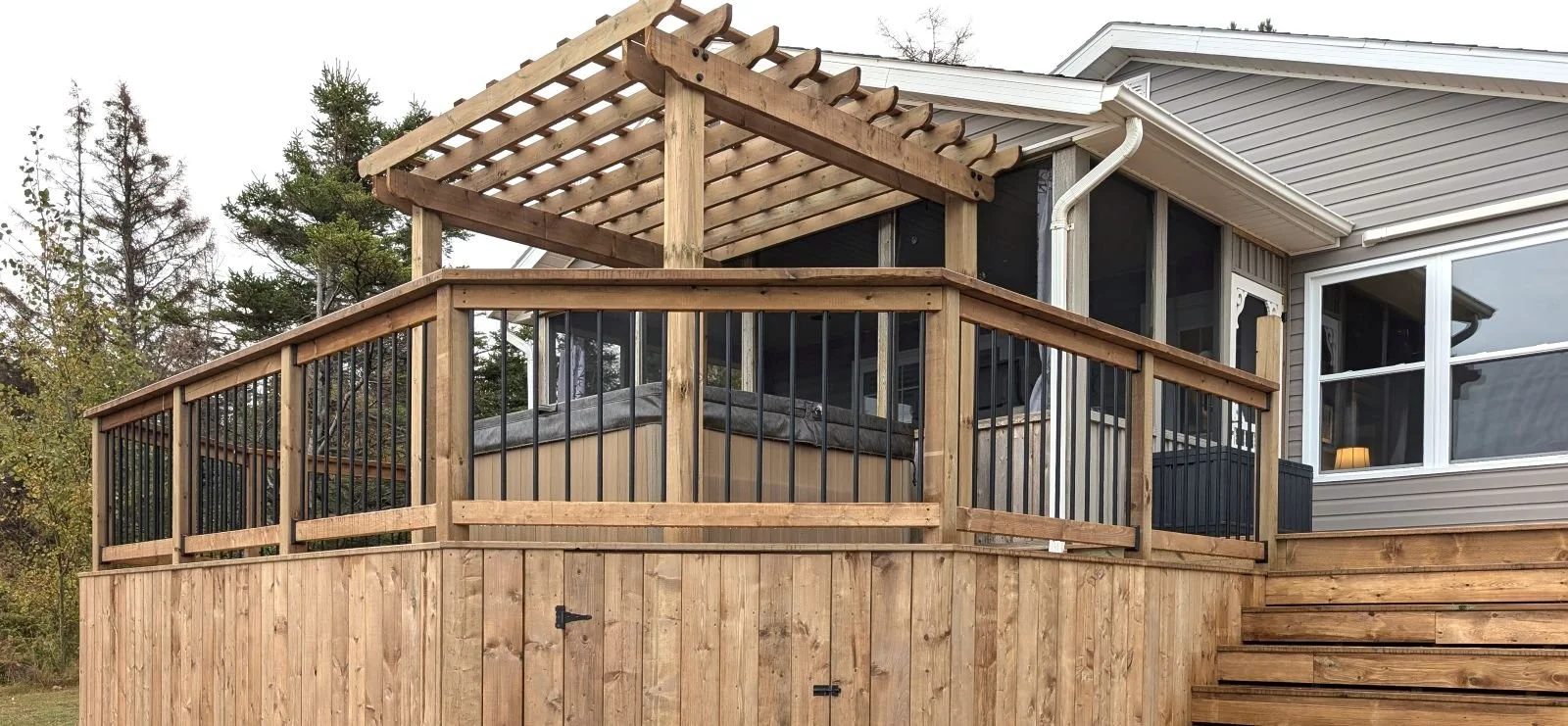 Custom designed and built pressure treated wood and black aluminum railings on multi level deck built for home owner in West Covehead, PEI.