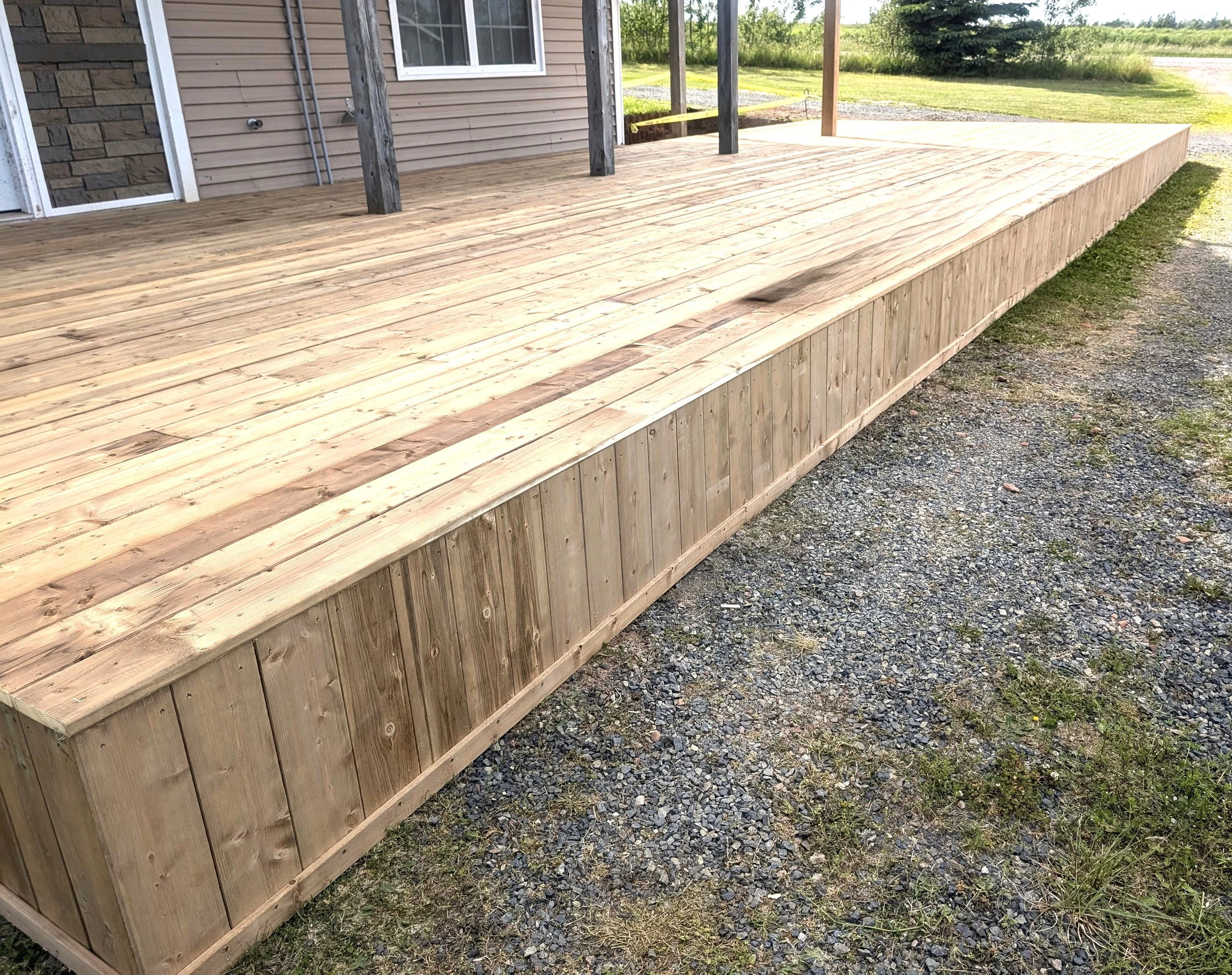 Custom built, pressure treated, ground level wooden deck built for a homeowner in North Rustico, PEI.