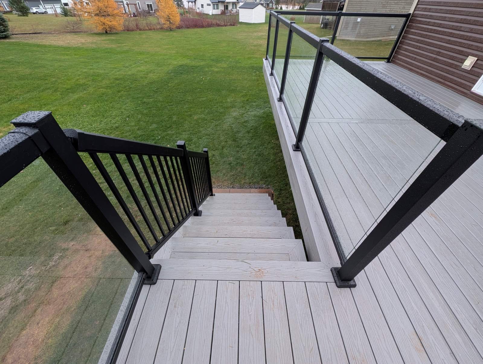 Custom designed and built glass and black aluminum railings on composite deck built for home owner in Cornwall, PEI.