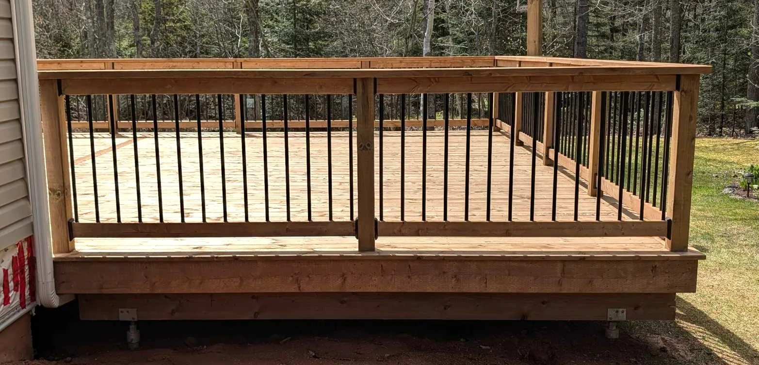 Custom designed and built pressure treated wood and black aluminum railings on deck built for home owner in Brackley Beach, PEI.