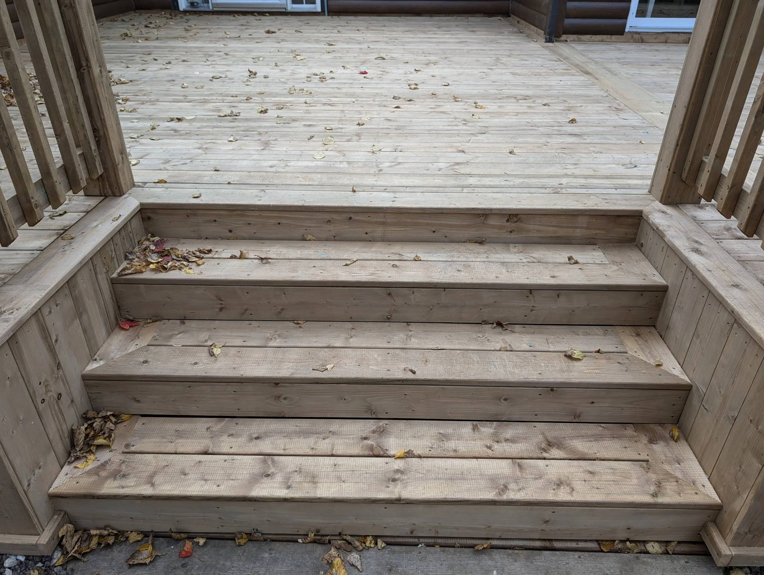 Custom design and built, pressure treated, wooden deck with inset stairs and wood railing built for homeowner in Stanley Bridge, PEI