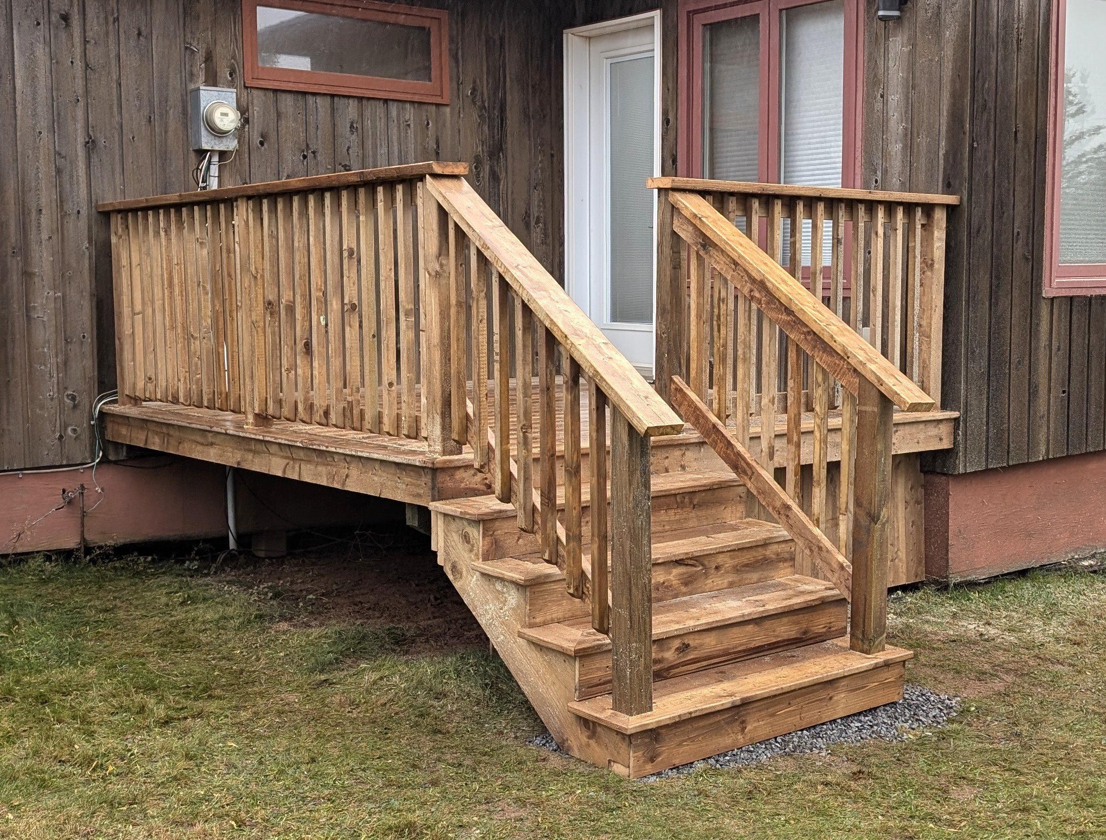 Custom design and built, pressure treated, wooden deck with stairs and wood railing built for homeowner in Stanley Bridge, PEI