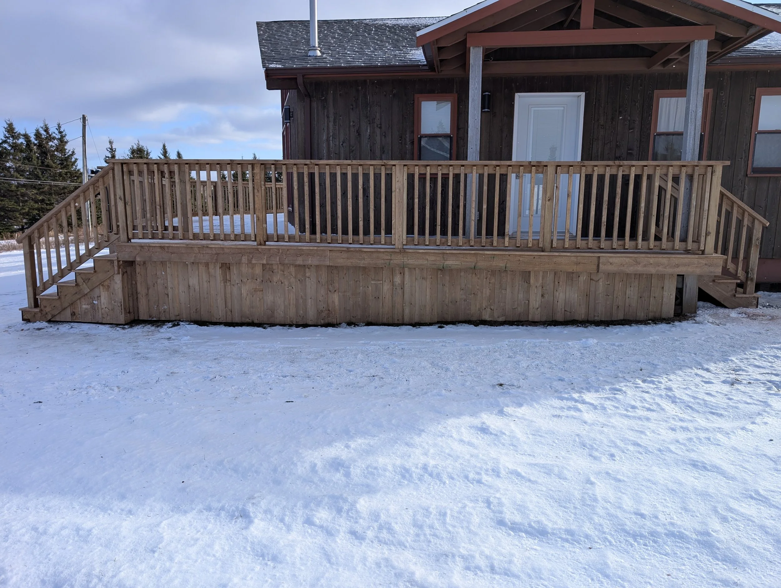 Custom designed and built pressure treated wood railings on deck for cottage owner in Stanley Bridge, PEI.