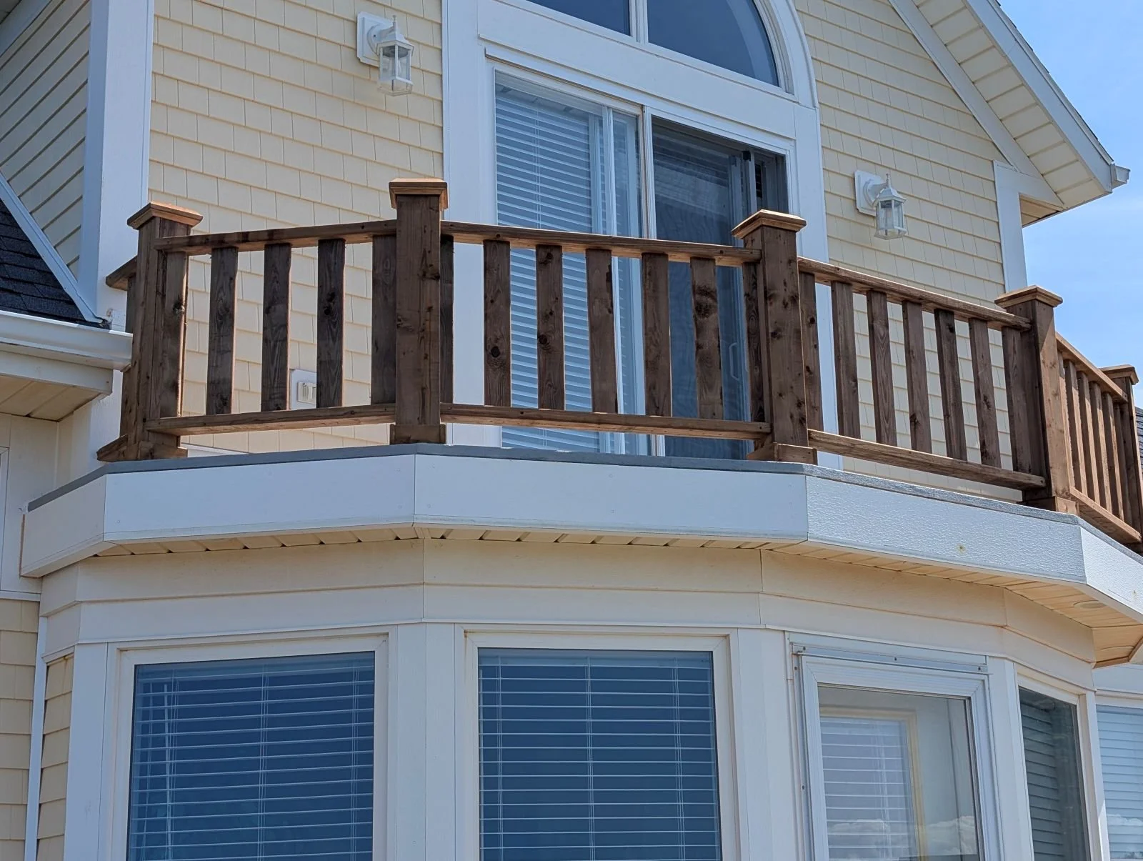 Custom designed and built pressure treated wood railings on upper deck walkout built for cottage owner in Canoe Cove, PEI.