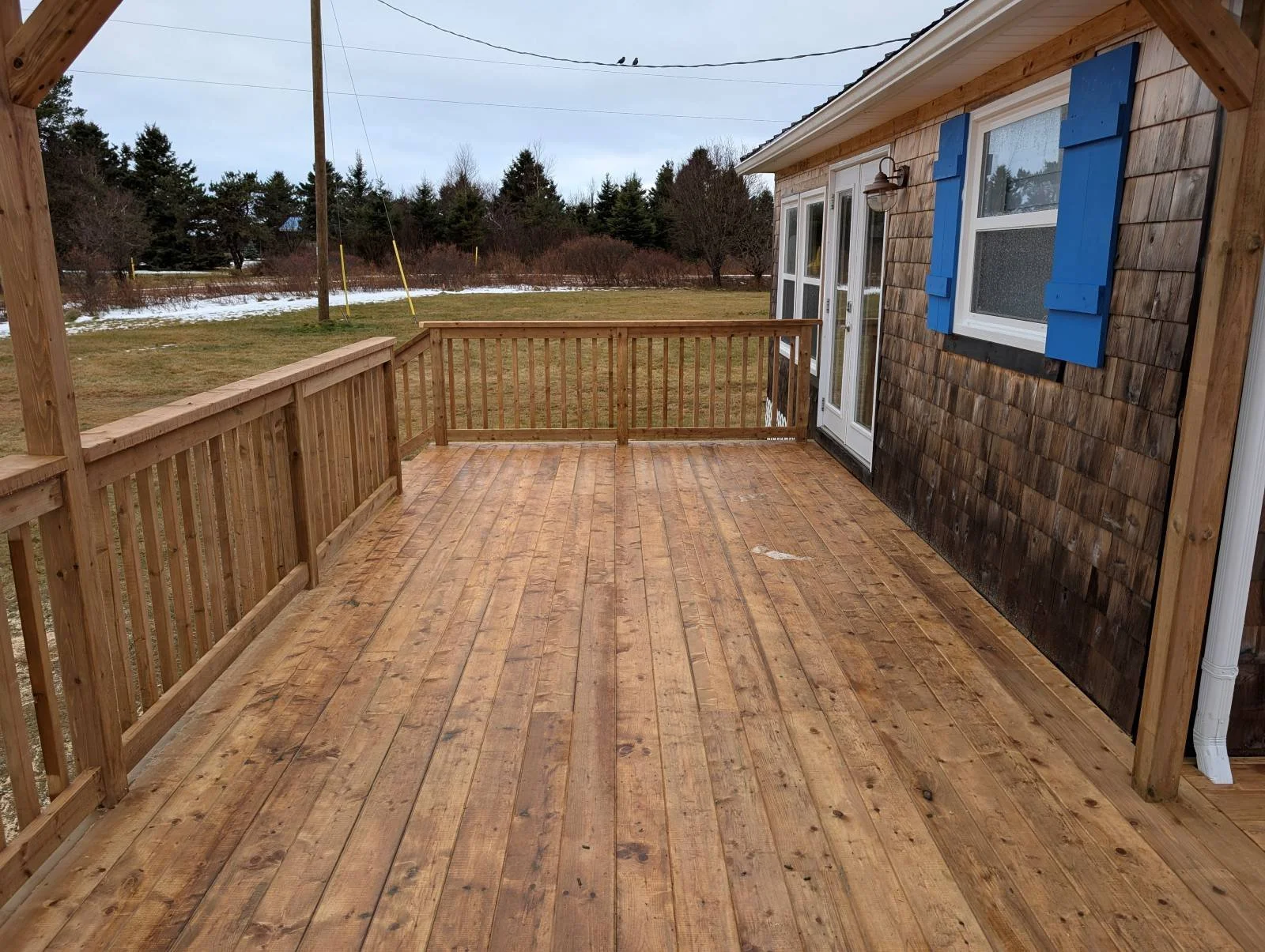 Custom designed and built pressure treated wooden railings on deck built for cottage owner in Canoe Cove, PEI.