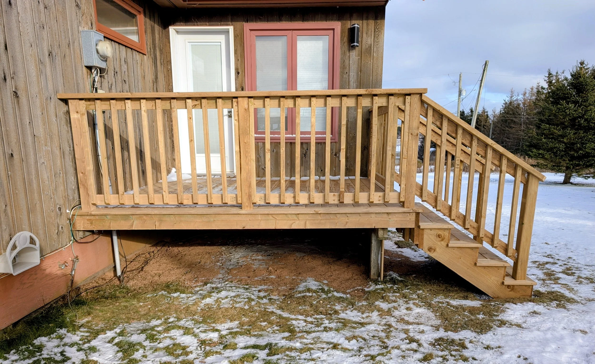 Custom designed and built pressure treated wood railings on deck for cottage owner in Stanley Bridge, PEI.
