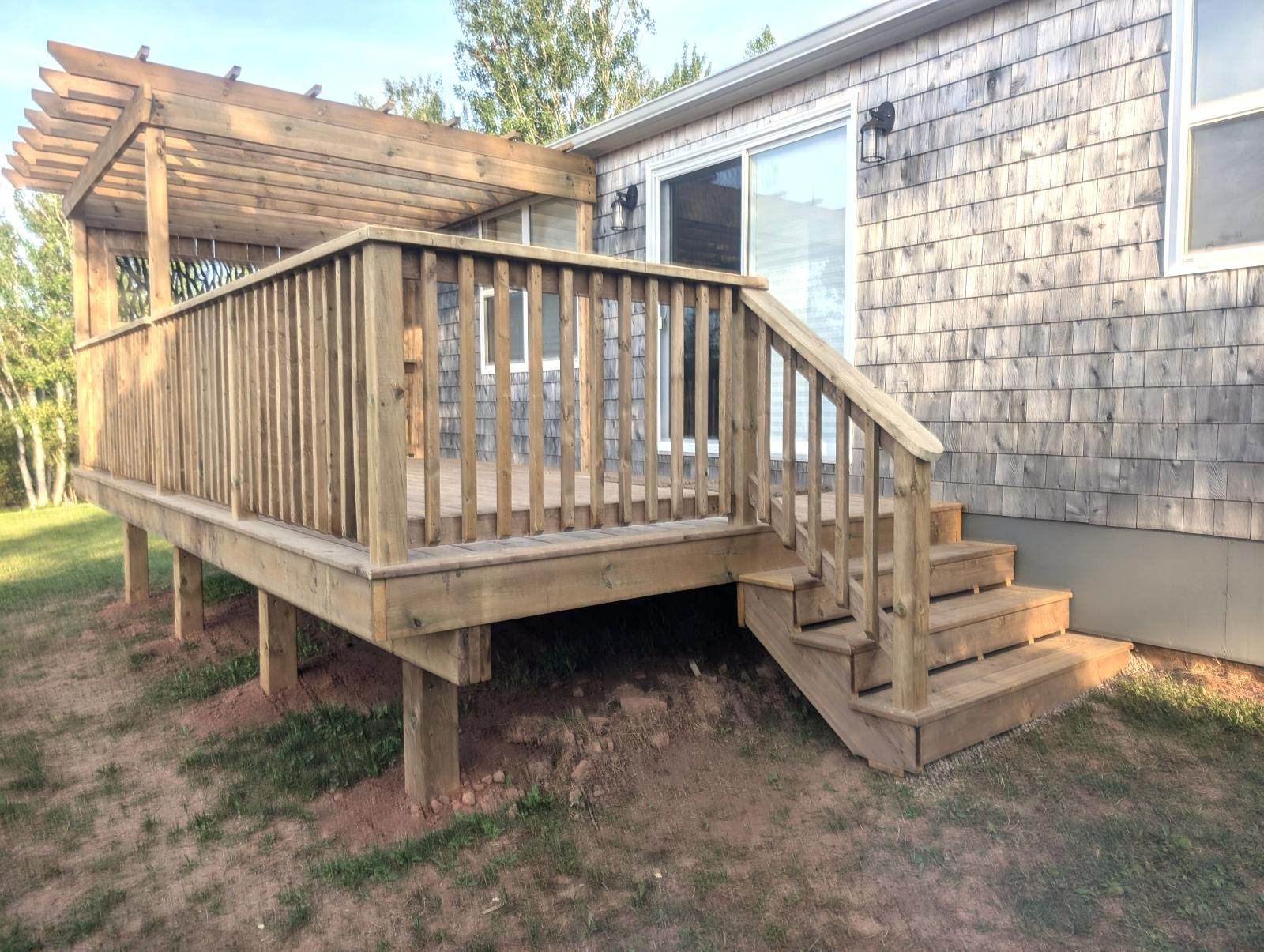 Custom designed and built pressure treated wood railings on deck for cottage owner in Stanley Bridge, PEI.