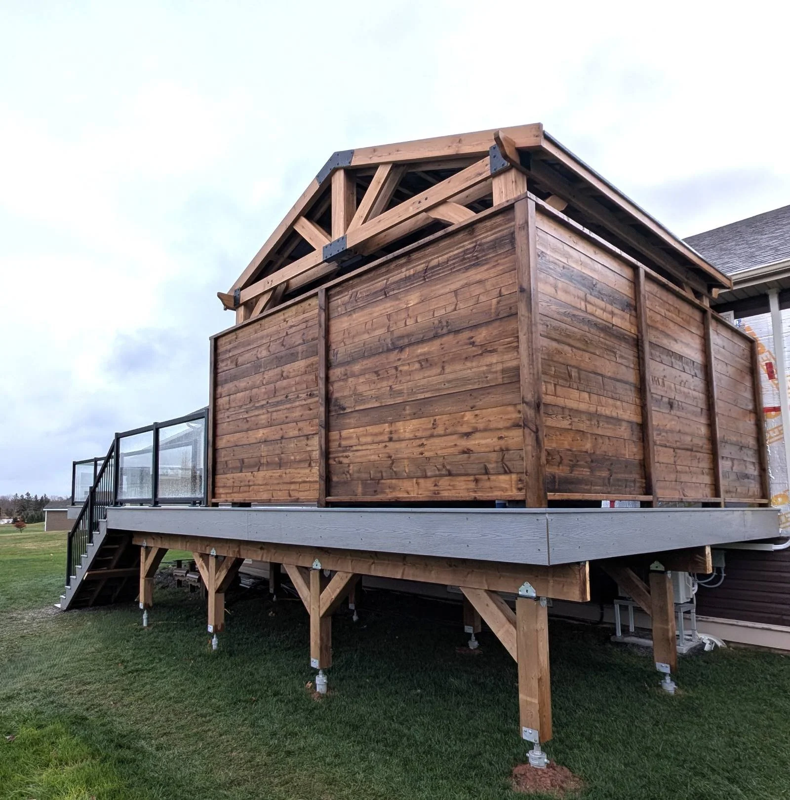 Pressure treated gazebo with metal roof, on grey composite deck with glass and black aluminum railings built for a home owner in Cornwall, PEI