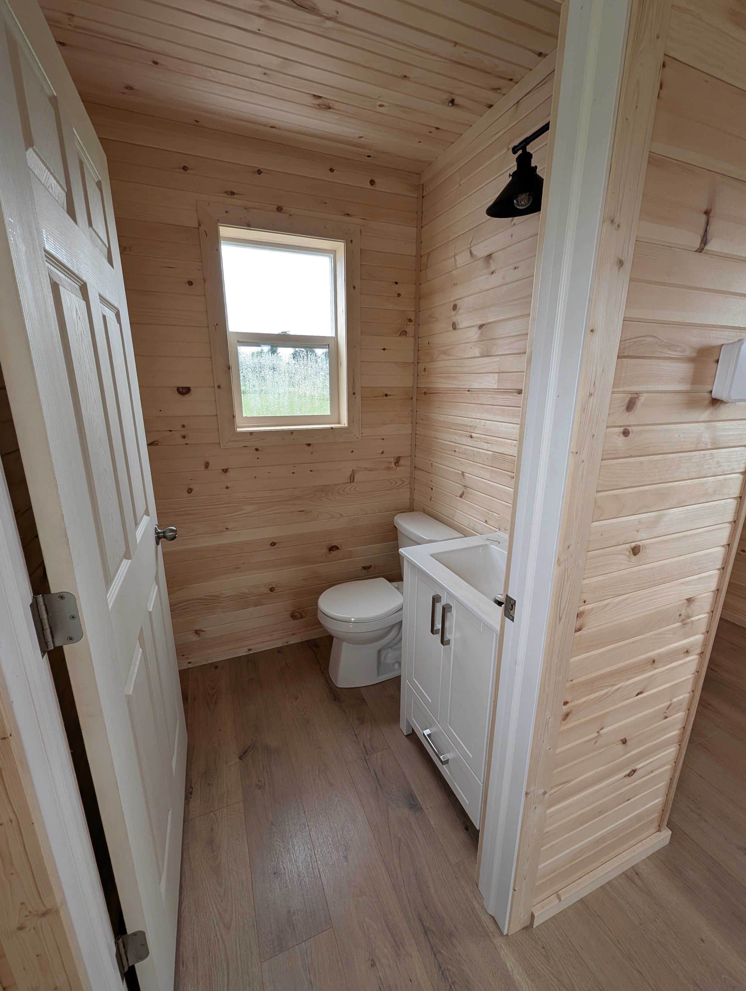 Custom designed and built 12 x 16 Bunk House with pine interior and half bath built for cottage owner in Canoe Cove, PEI.