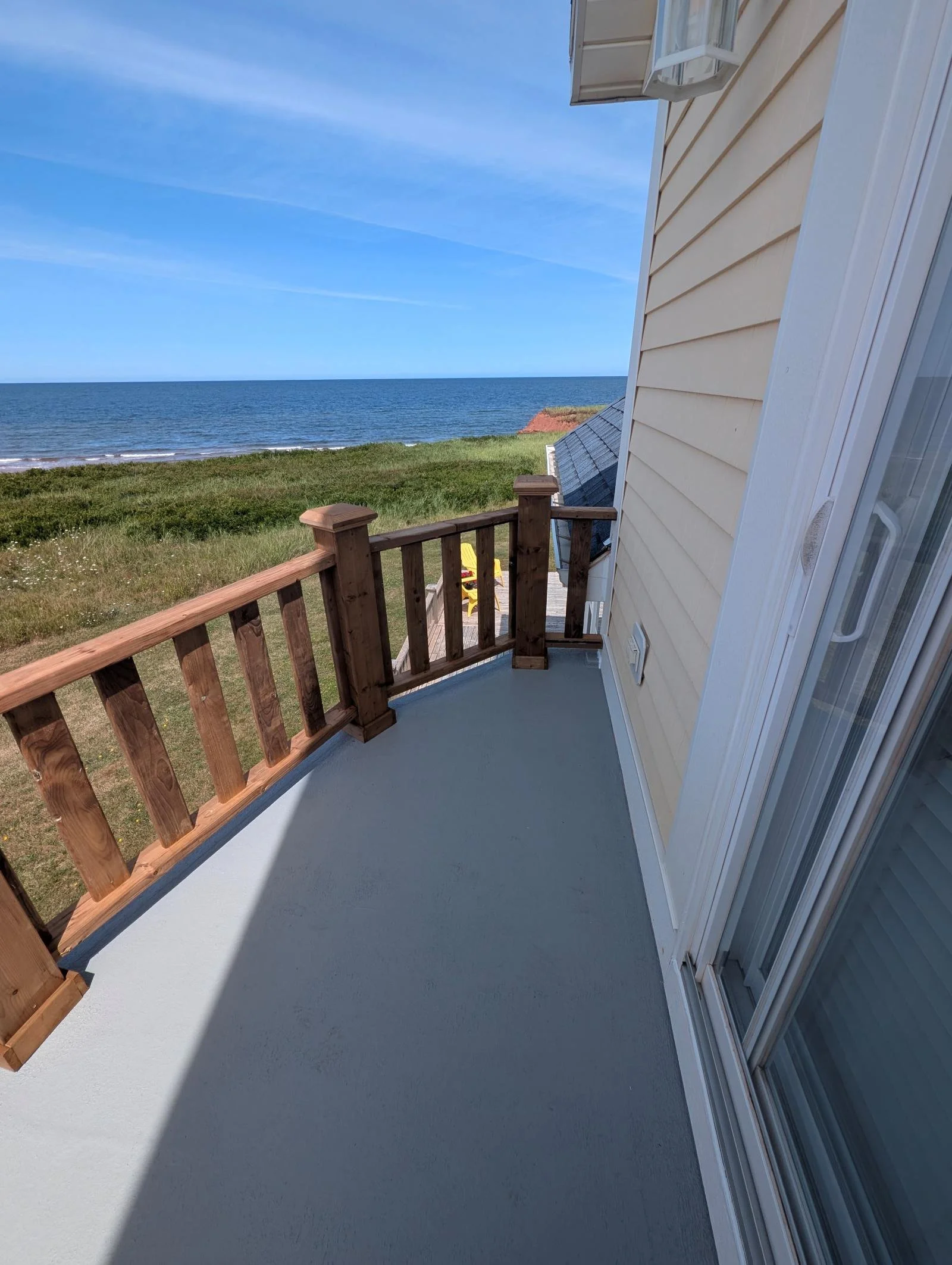 Custom designed and built pressure treated wood railings on upper deck walkout built for cottage owner in Canoe Cove, PEI.