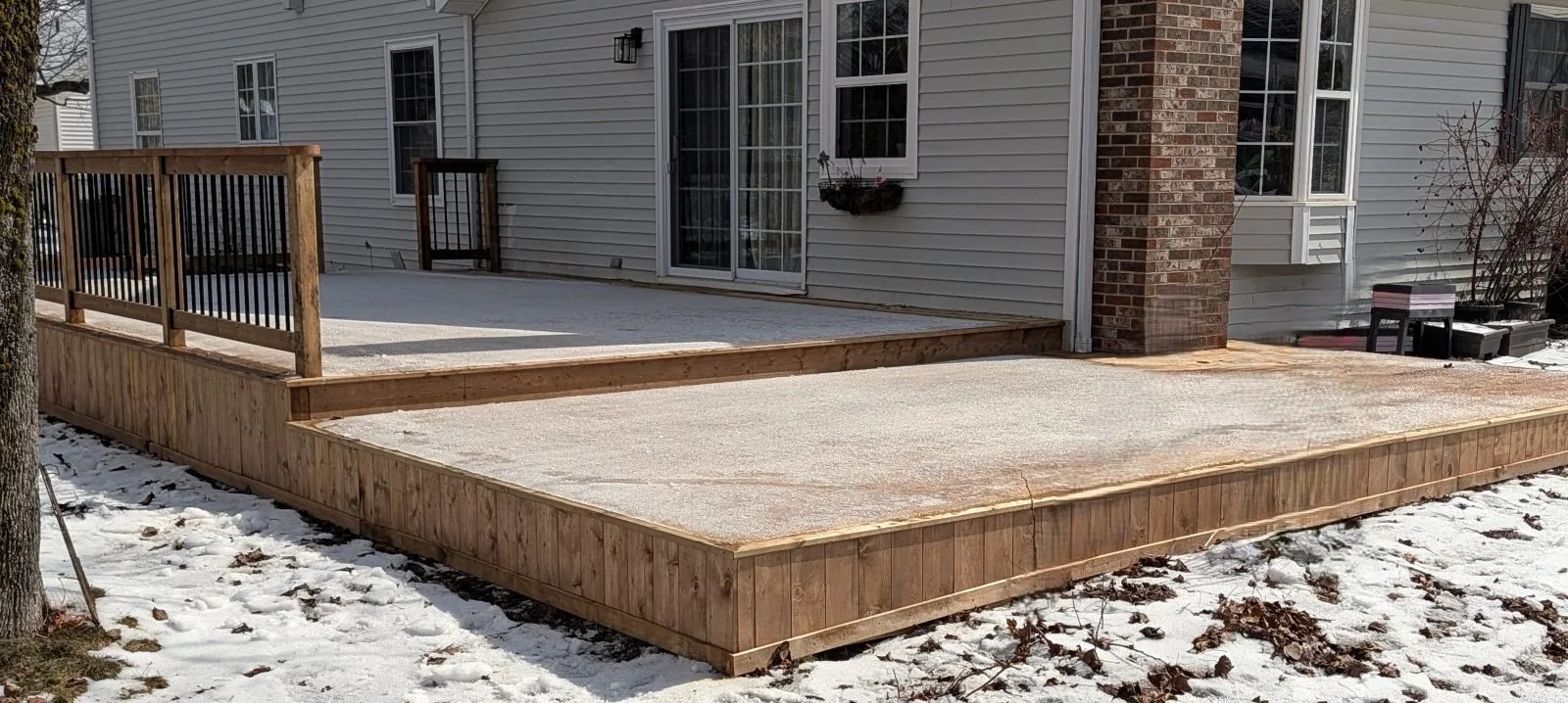 Custom built, pressure treated, ground level wooden deck with wood & black aluminum railings, built in early Spring for a home owner in Charlottetown, PEI.