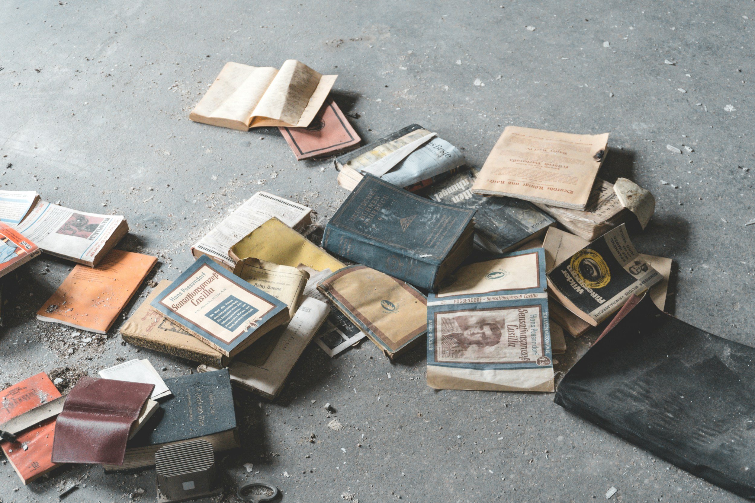 Scattered old books and papers on a dusty floor