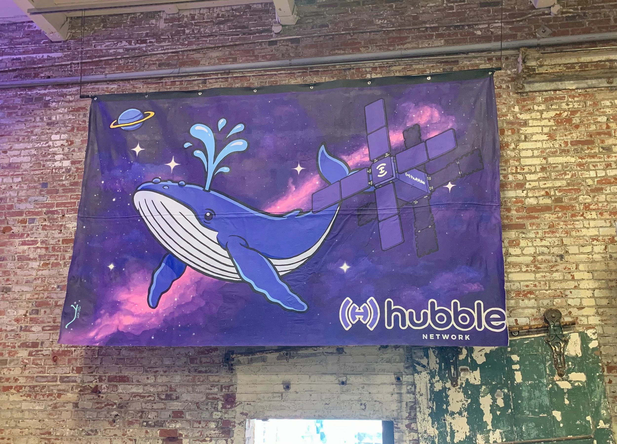 A banner featuring a blue whale with water splashing from its blowhole, set against a space-themed background with stars and a galaxy. The banner includes the logo and name of the Hubble Network.