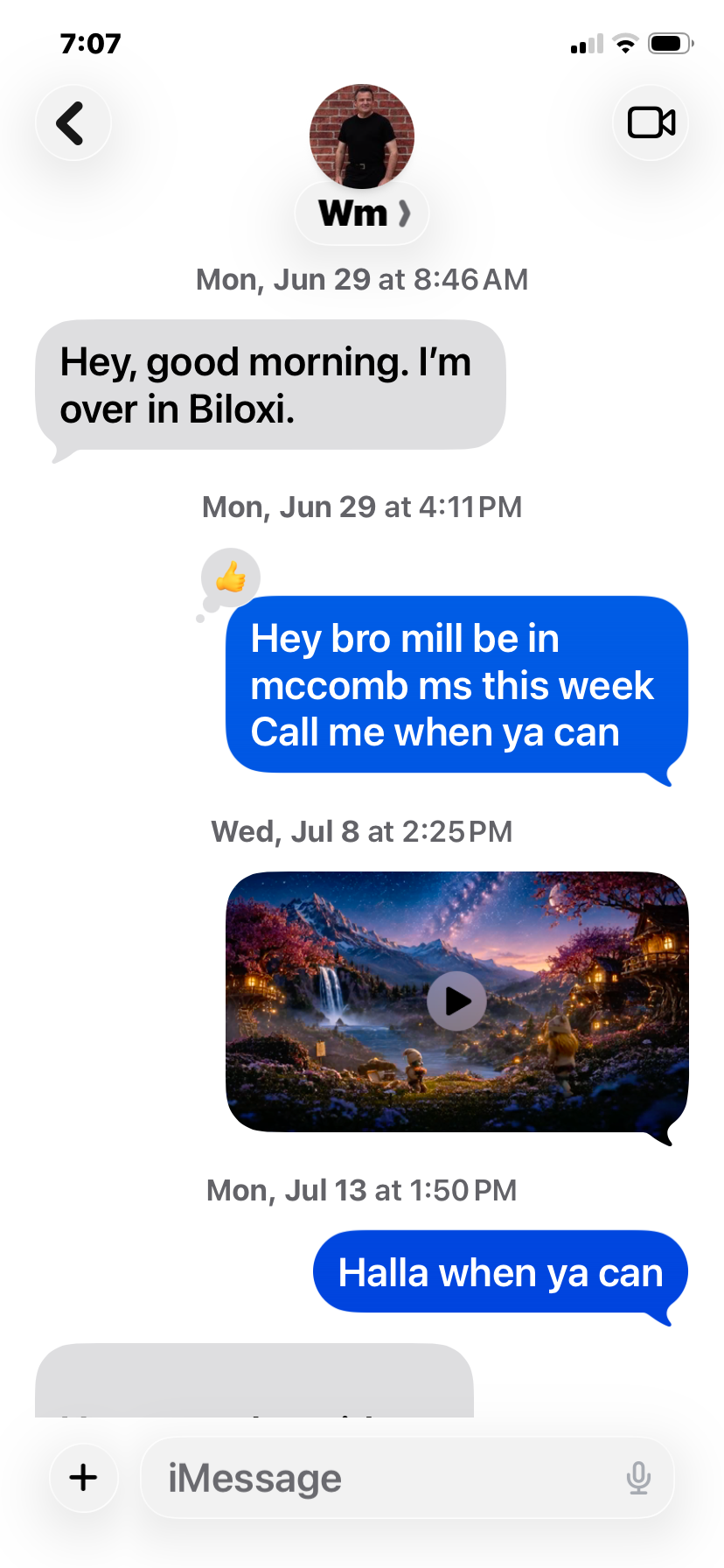 Text message conversation on a phone screen showing messages between two people, one mentioning they're in Biloxi and the other sending a scenic nature video link.