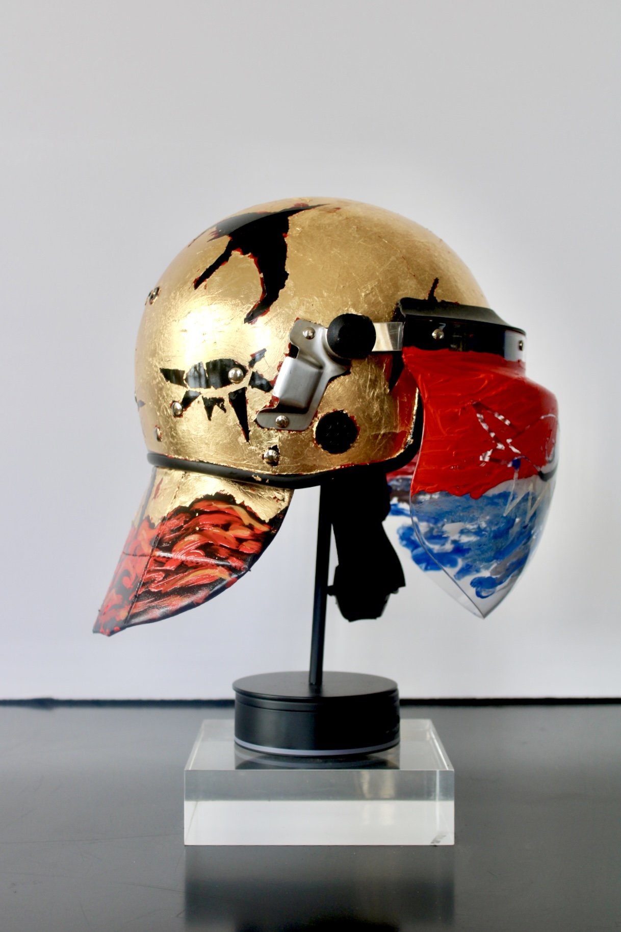 When the  River Runs Red" [side view]

Acrylic and Imitation Gold Leaf on Police Riot Helmet
18" x 12" x 10.5"
2024