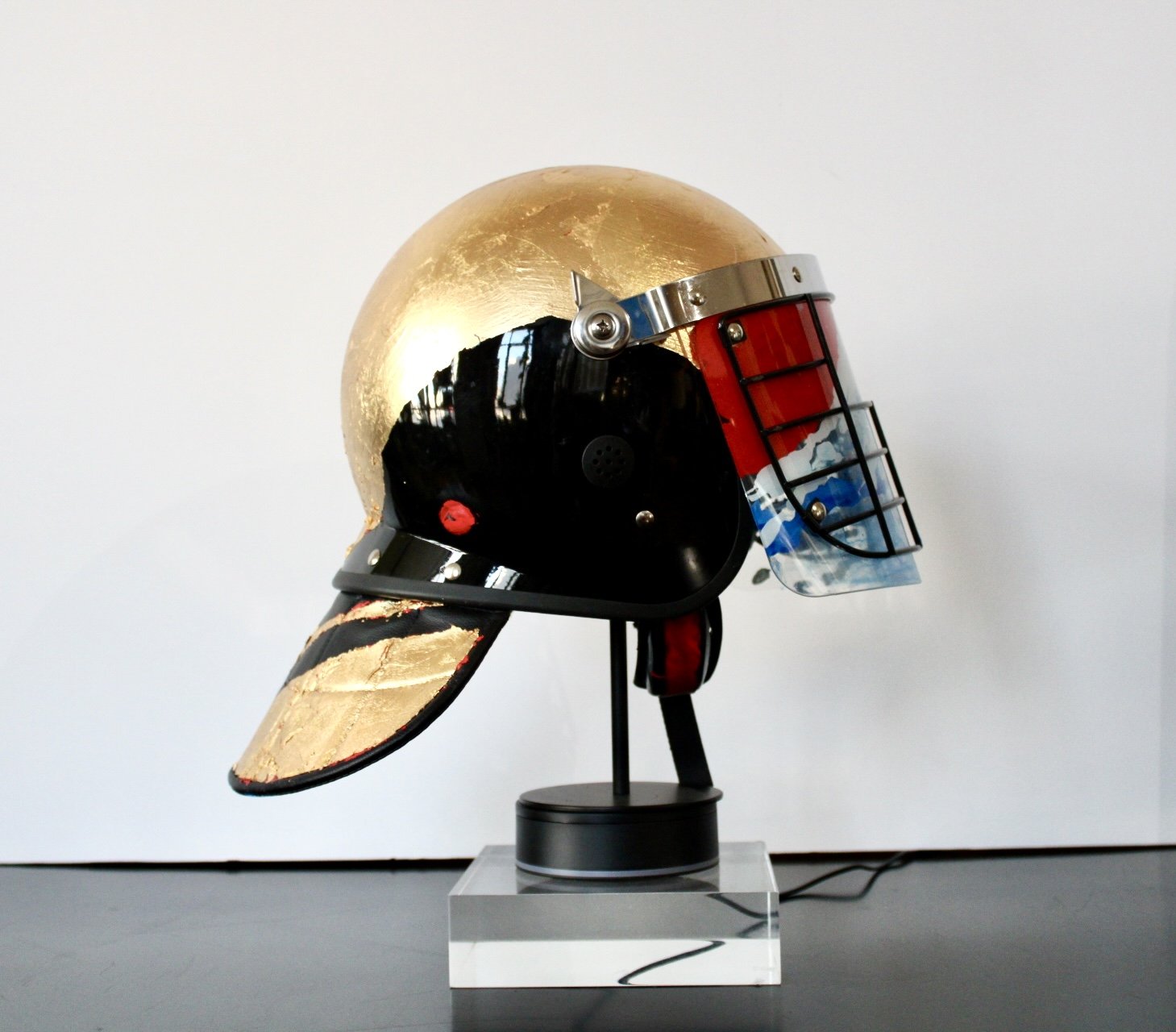 "When the Mountain Blesses the Rain" [side view]

Acrylic and Imitation Gold Leaf on Police Riot Helmet
18" x 12" x 10.5"
2024
