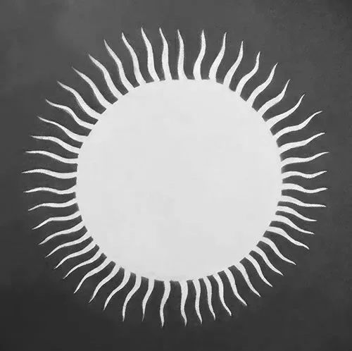 Black and white image of a circular sun symbol with wavy rays extending outward.