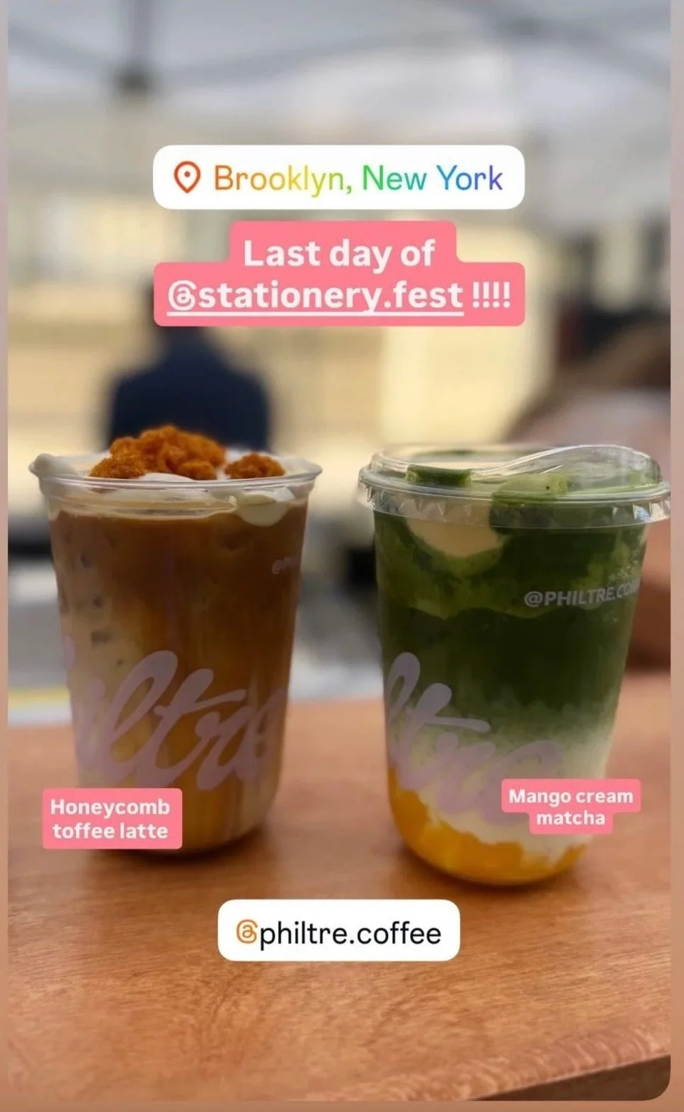 Two colorful beverages on a wooden table with a blurred background. The drink on the left is labeled Honeycomb toffee latte, topped with a frothy layer. The drink on the right is labeled Mango cream matcha, with a green matcha layer, mango chunks, and cream.