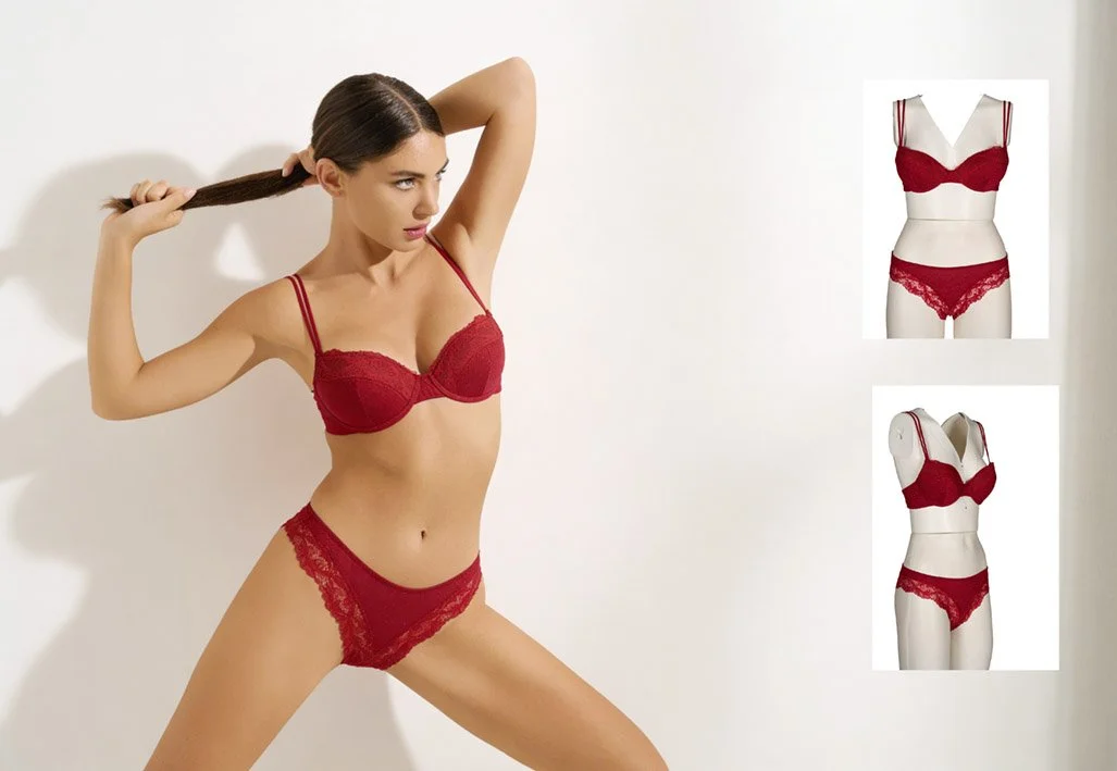 Donna con capelli lunghi che indossa un reggiseno e slip di pizzo rossi, posa contro una parete bianca.
