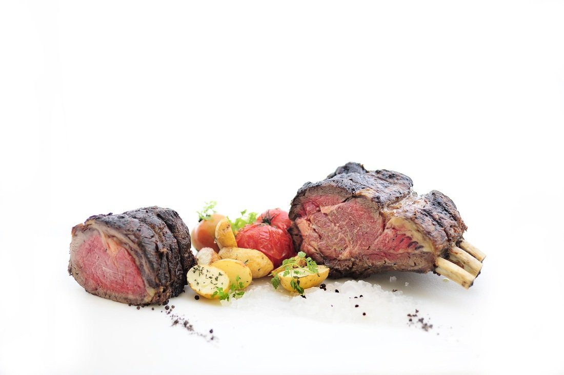 Cooked beef tenderloin with potatoes, cherry tomatoes, and herbs