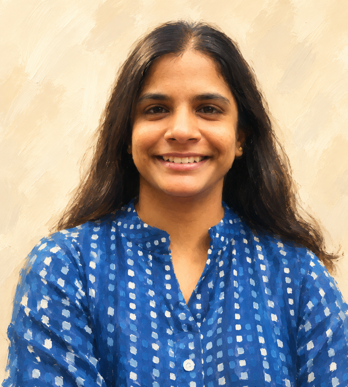 Portrait of a smiling woman with long dark hair wearing a blue patterned blouse against a neutral background.