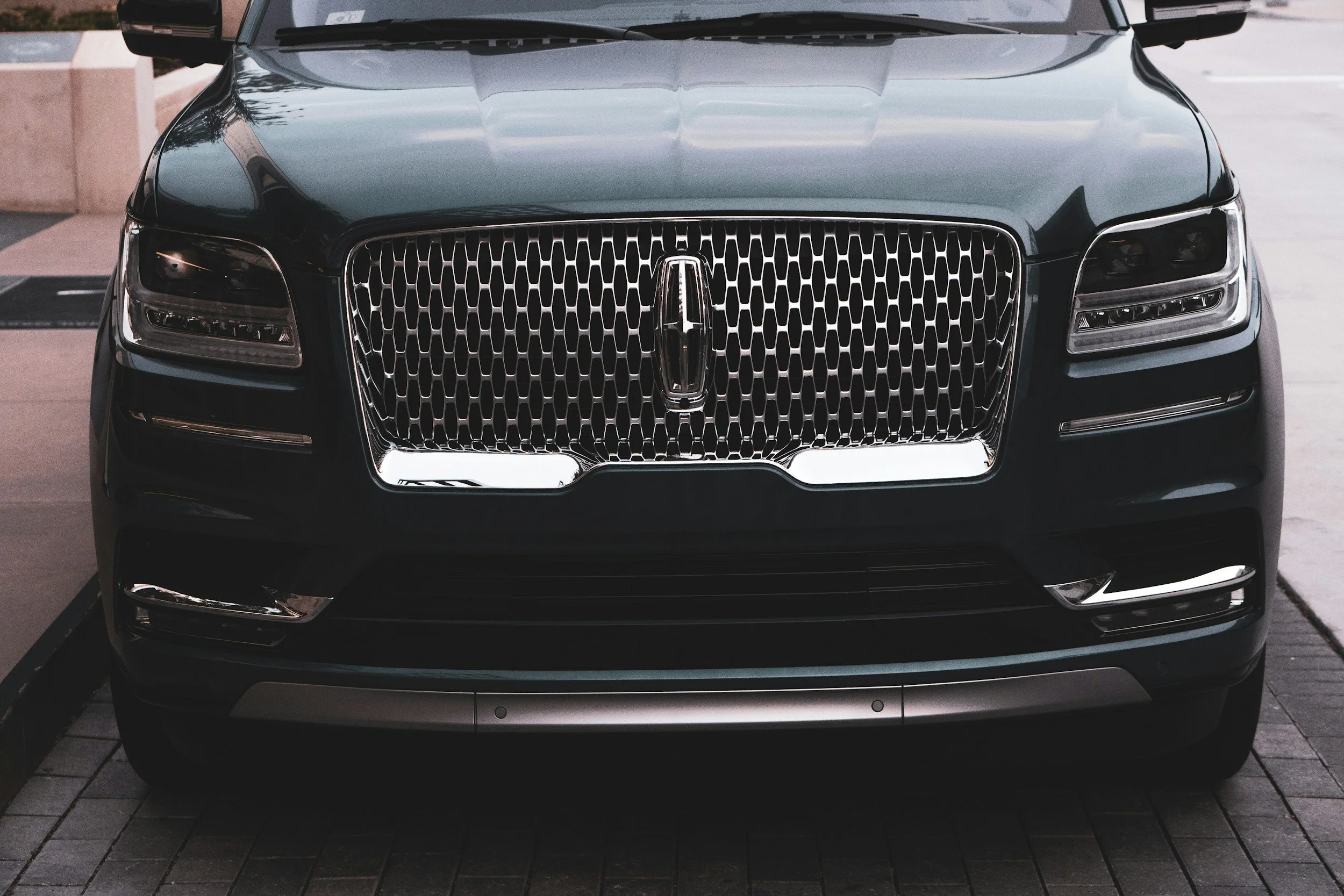 Front view of a black Lincoln Navigator SUV parked on a city street.