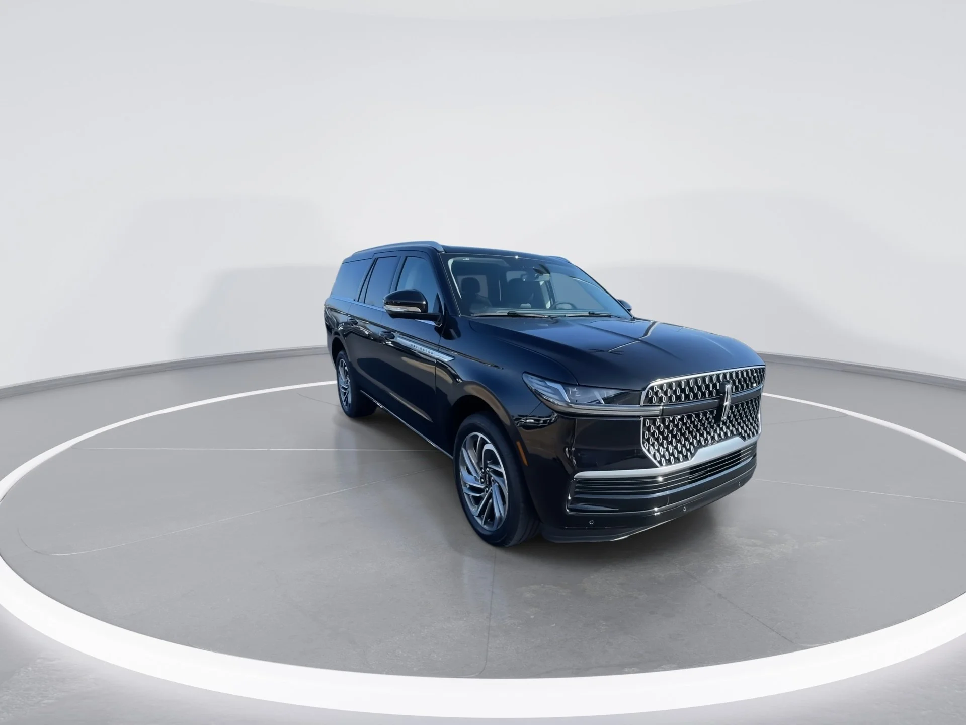 A black luxury SUV with modern design parked in a white circular studio.