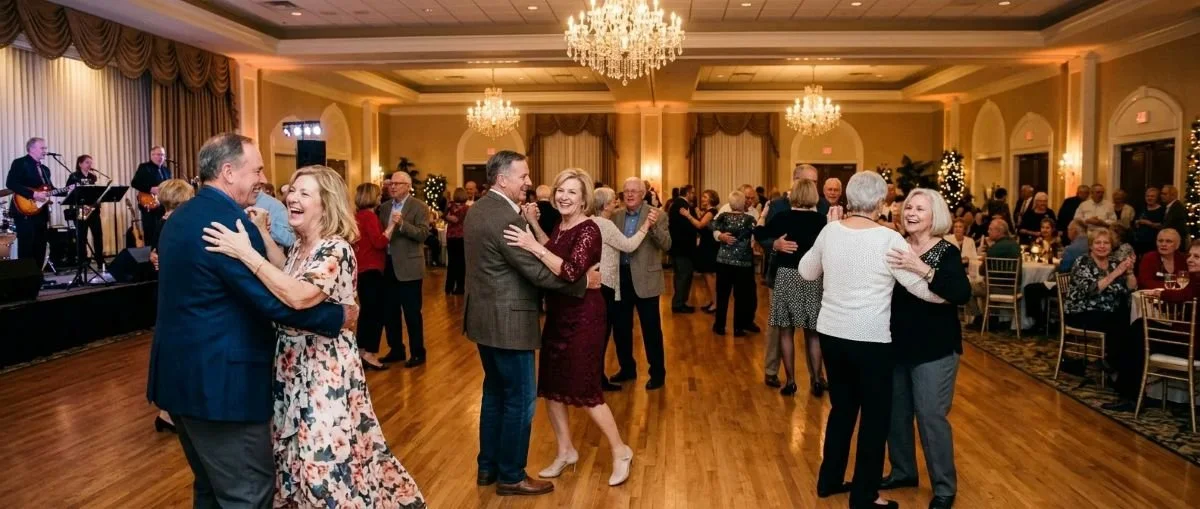 People dancing and enjoying live music in a festive banquet hall decorated with Christmas trees and chandeliers.