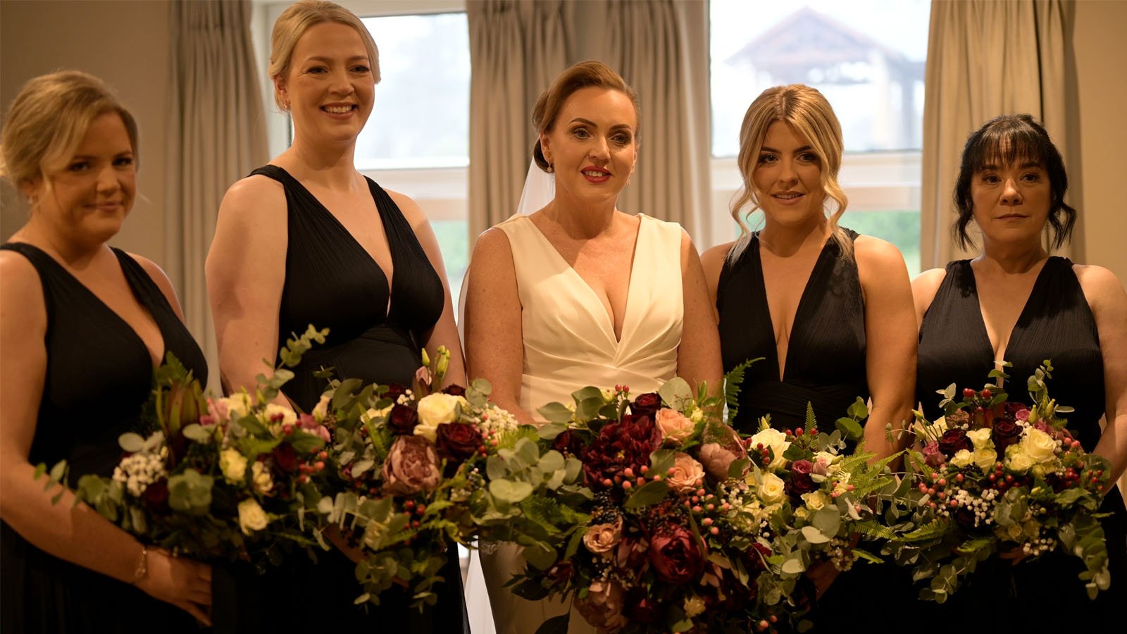  Bride and bridesmaids filmed with bouquets in the bedroom. 