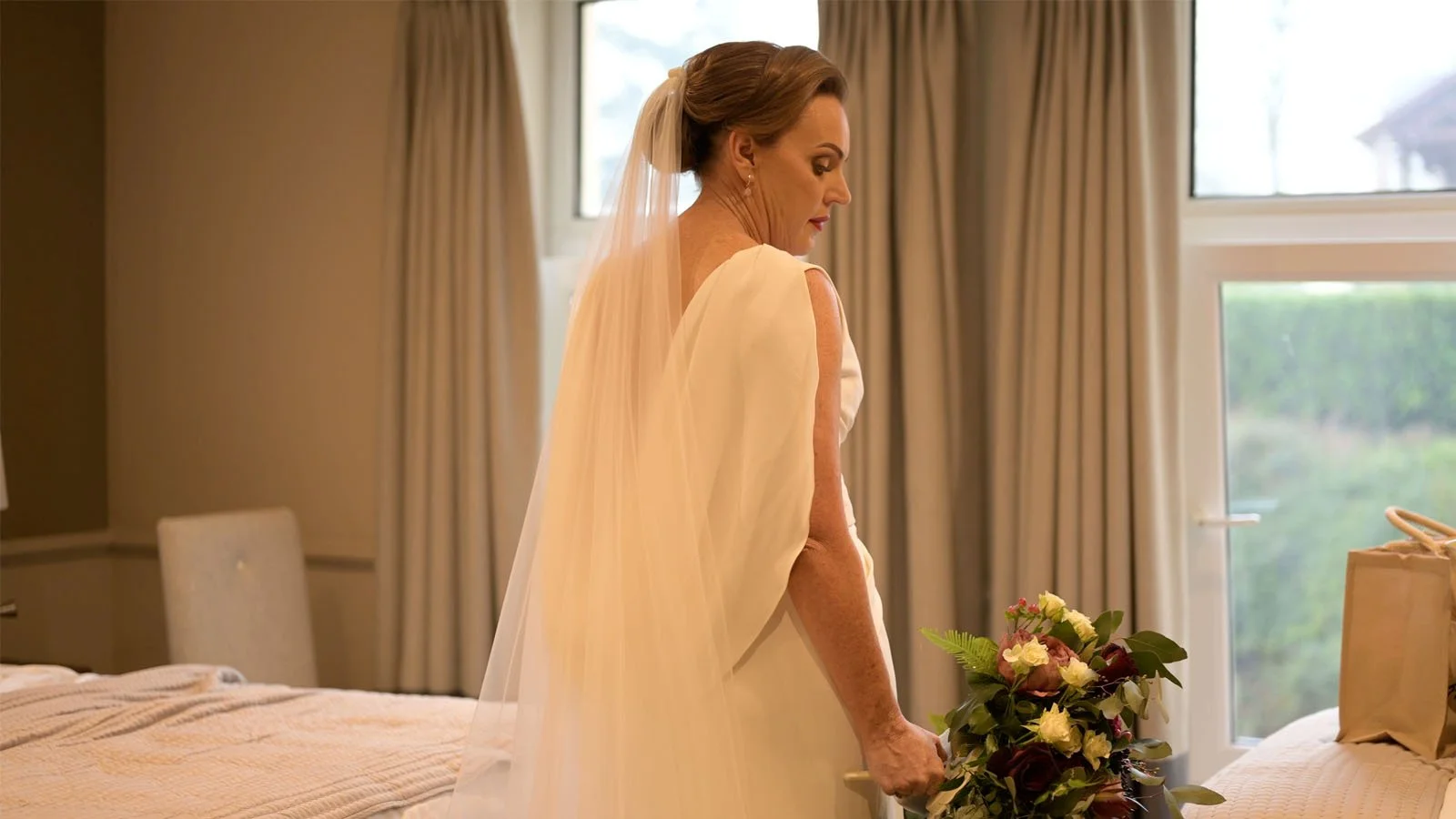  Filmed from the back showing the dress with the bride holding a bouquet.  