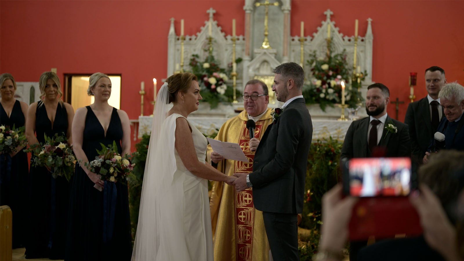  The bride and groom say vows as the Priest conducts the ceremony. 