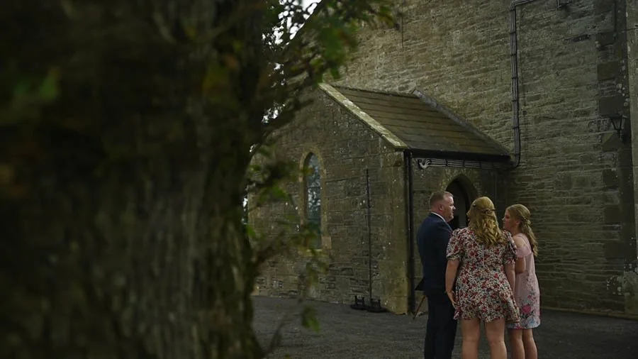 Outside of Church as three guests are chatting.