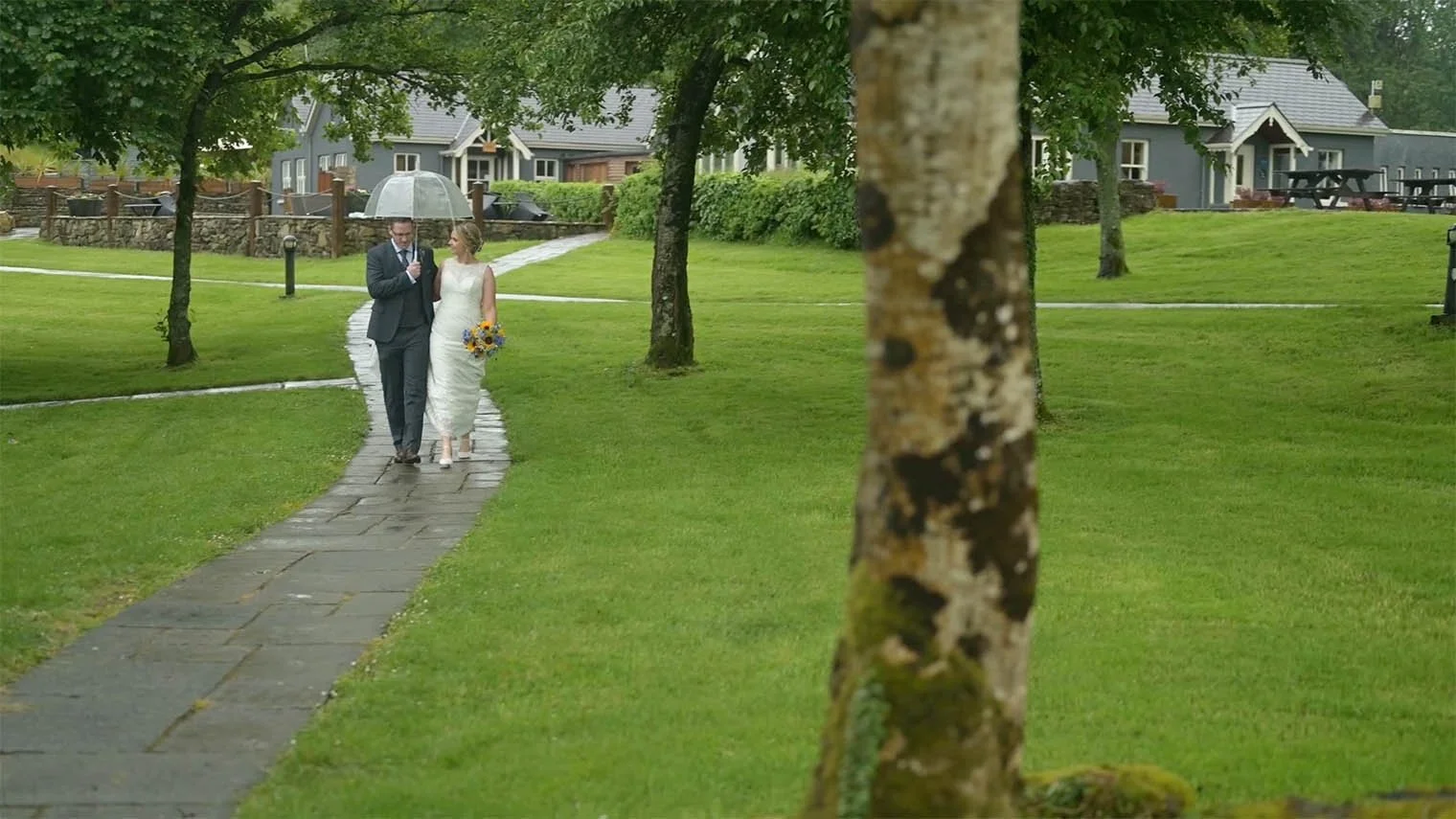 Lusty Beg Island Wedding with Bride and Groom walking under umbrella