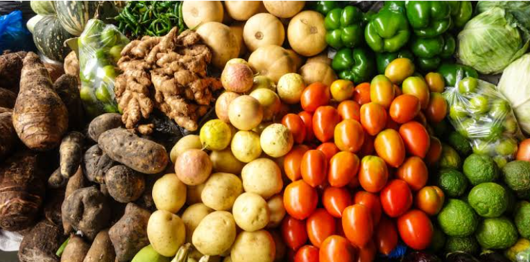 Assorted fresh vegetables including ginger, turnips, potatoes, apples, cherry tomatoes, green bell peppers, lettuce, and limes.