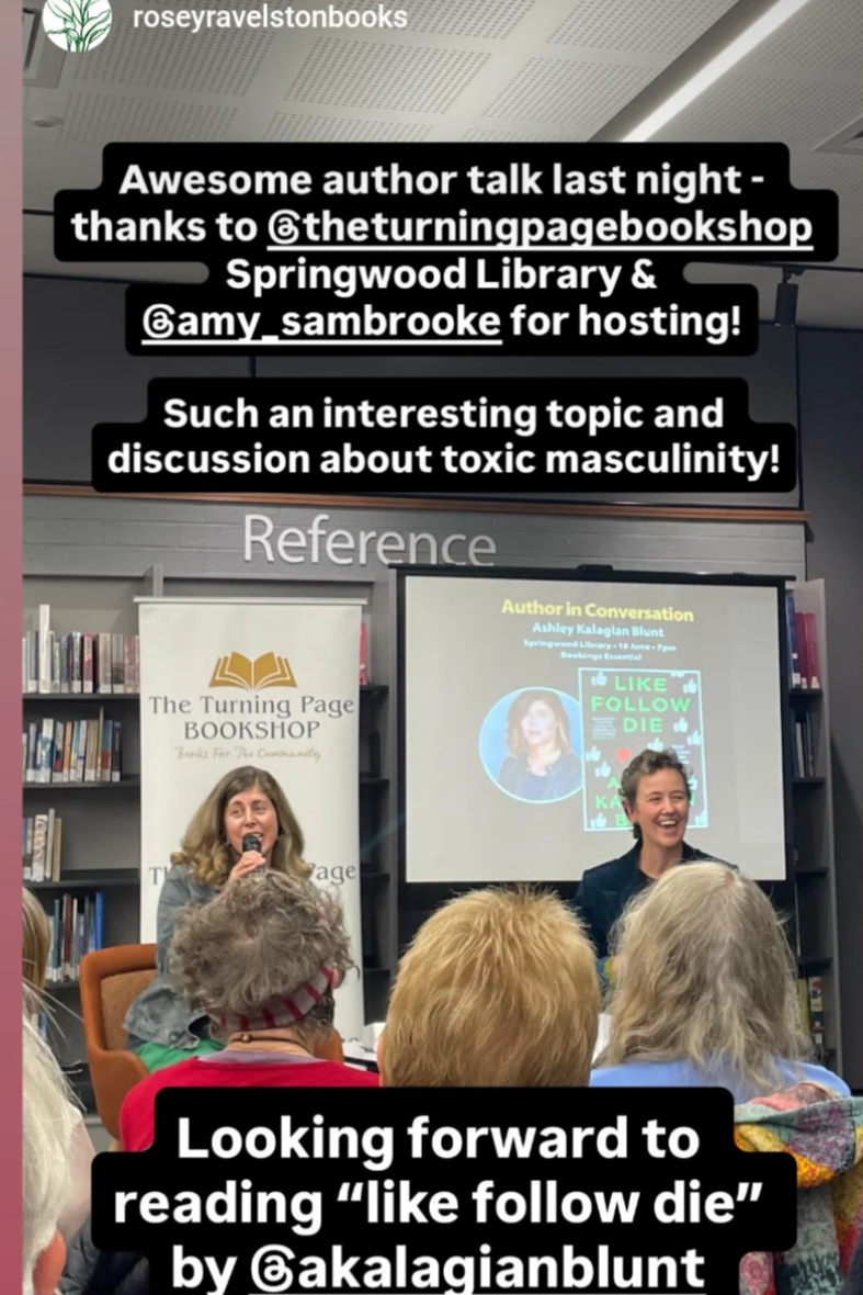 A group of people attending a book event at a library, featuring two women speaking at the front with a presentation screen and bookshelves in the background.