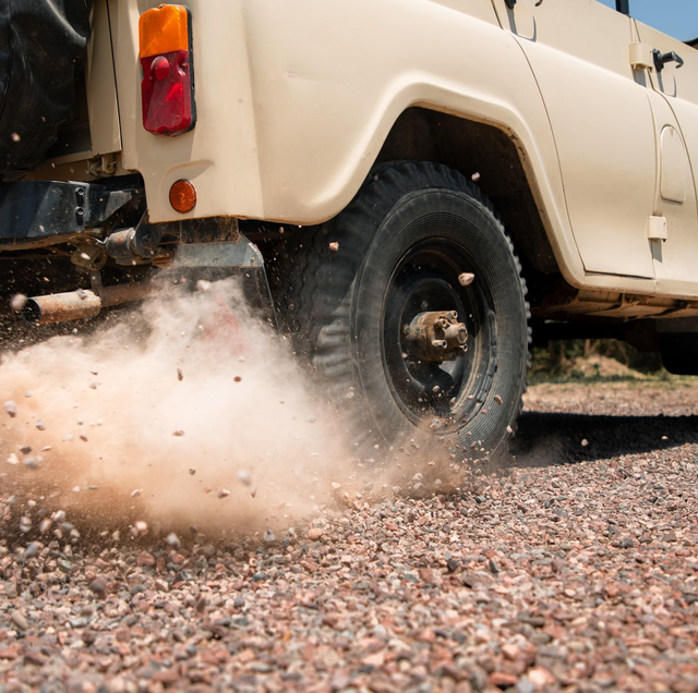 gravel driveway dust cloud rising from pickup truck wheels