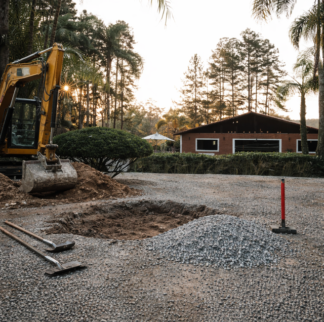 Fresh gravel fill beside a deep driveway pothole