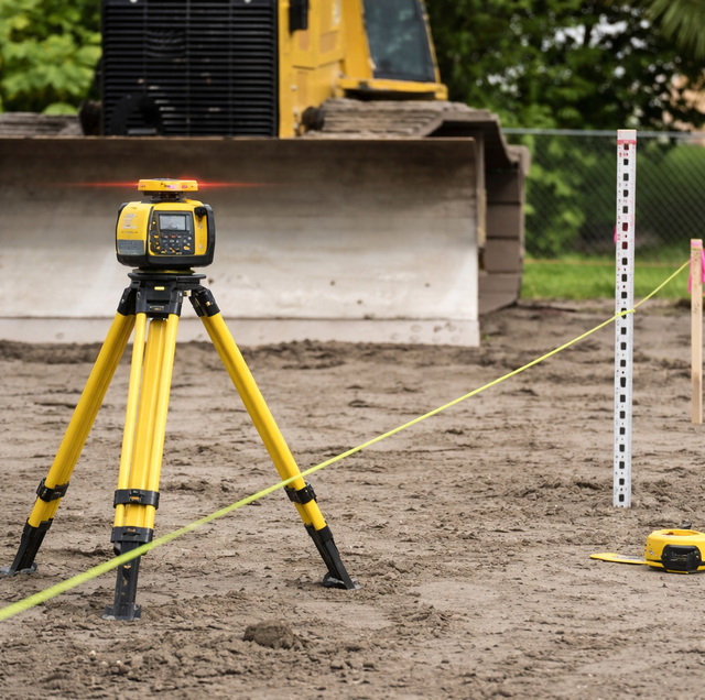 contractor checking slope with laser level and grade rod