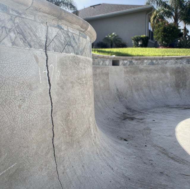 cracked concrete swimming pool with widening fissure
