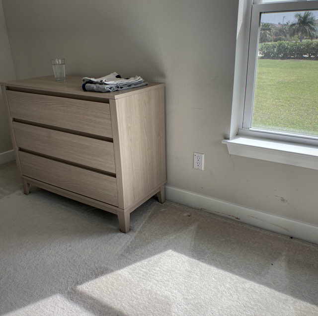 empty room with furniture stacked against baseboards